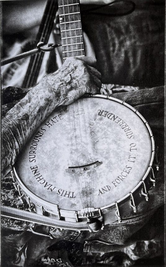 Hand holding banjo. Black and white photo.